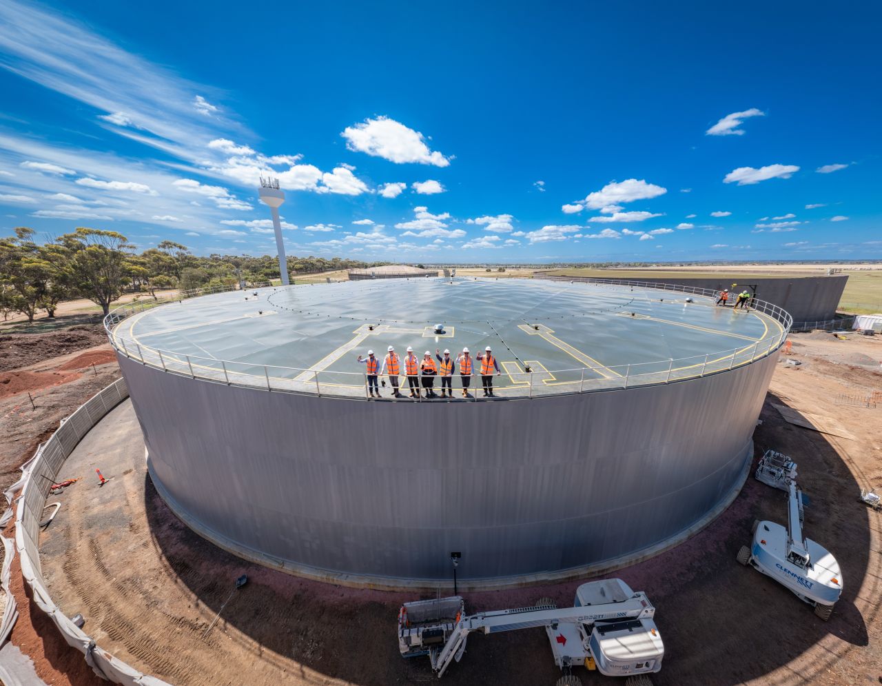 A group of GWW workers standing atop the new water tank.