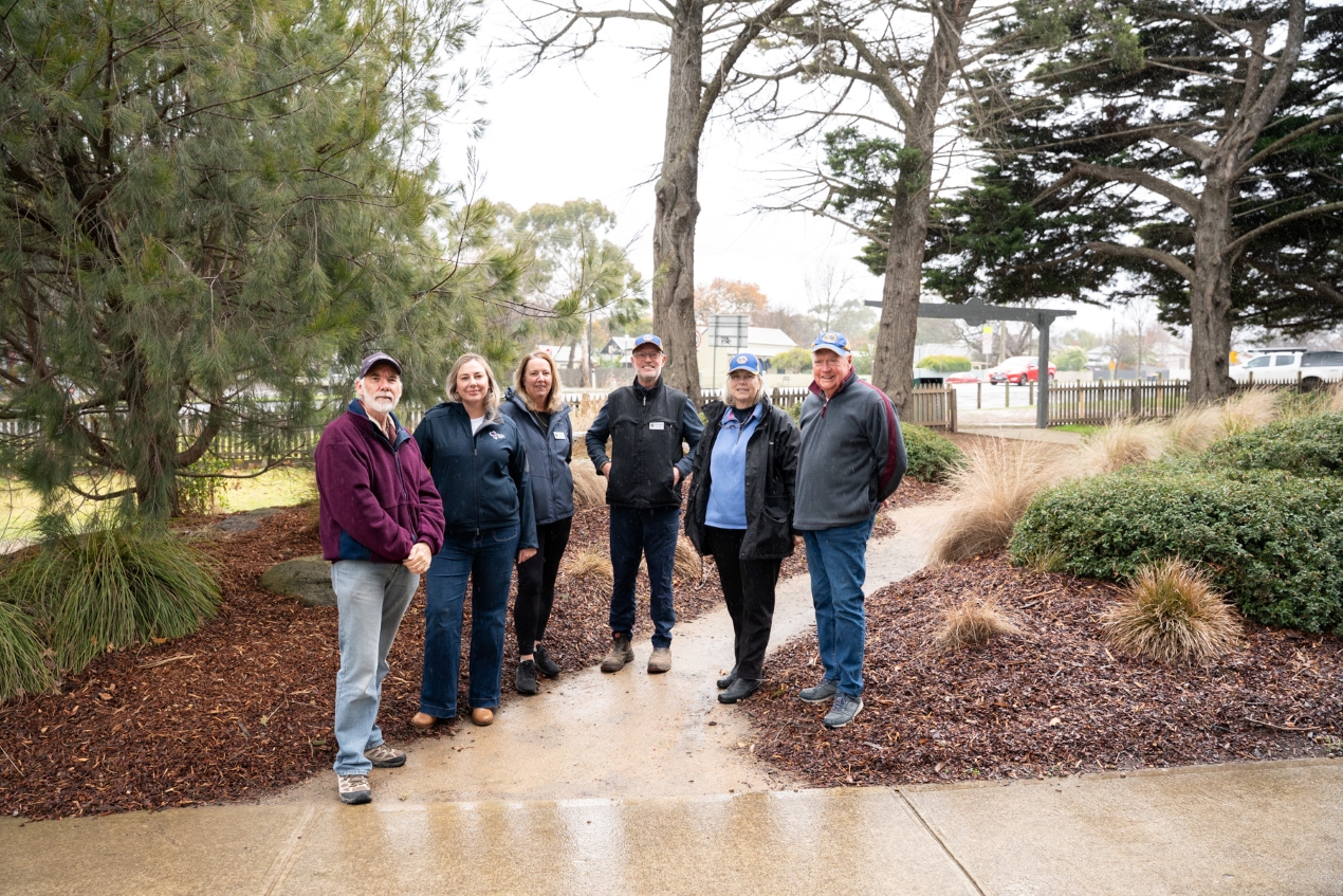 A group of 6 people standing in a public park