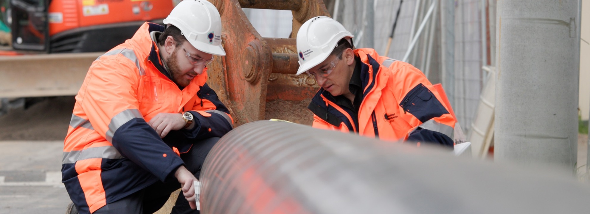 Greater Western Water engineers inspecting a large pipe.