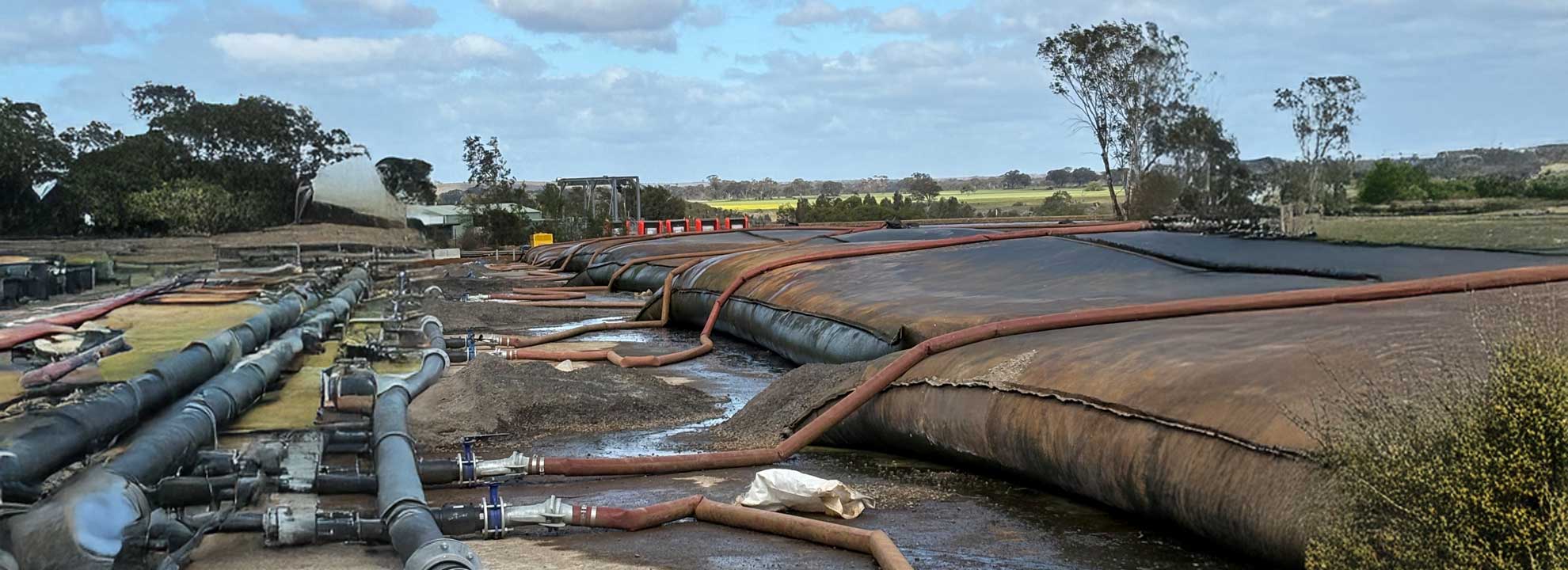 Very large, dirty bags filled with sludge that is being treated.