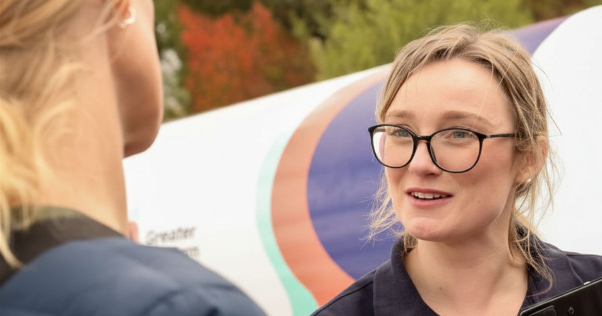 A GWW employee talking to customer with a water furphy in the background