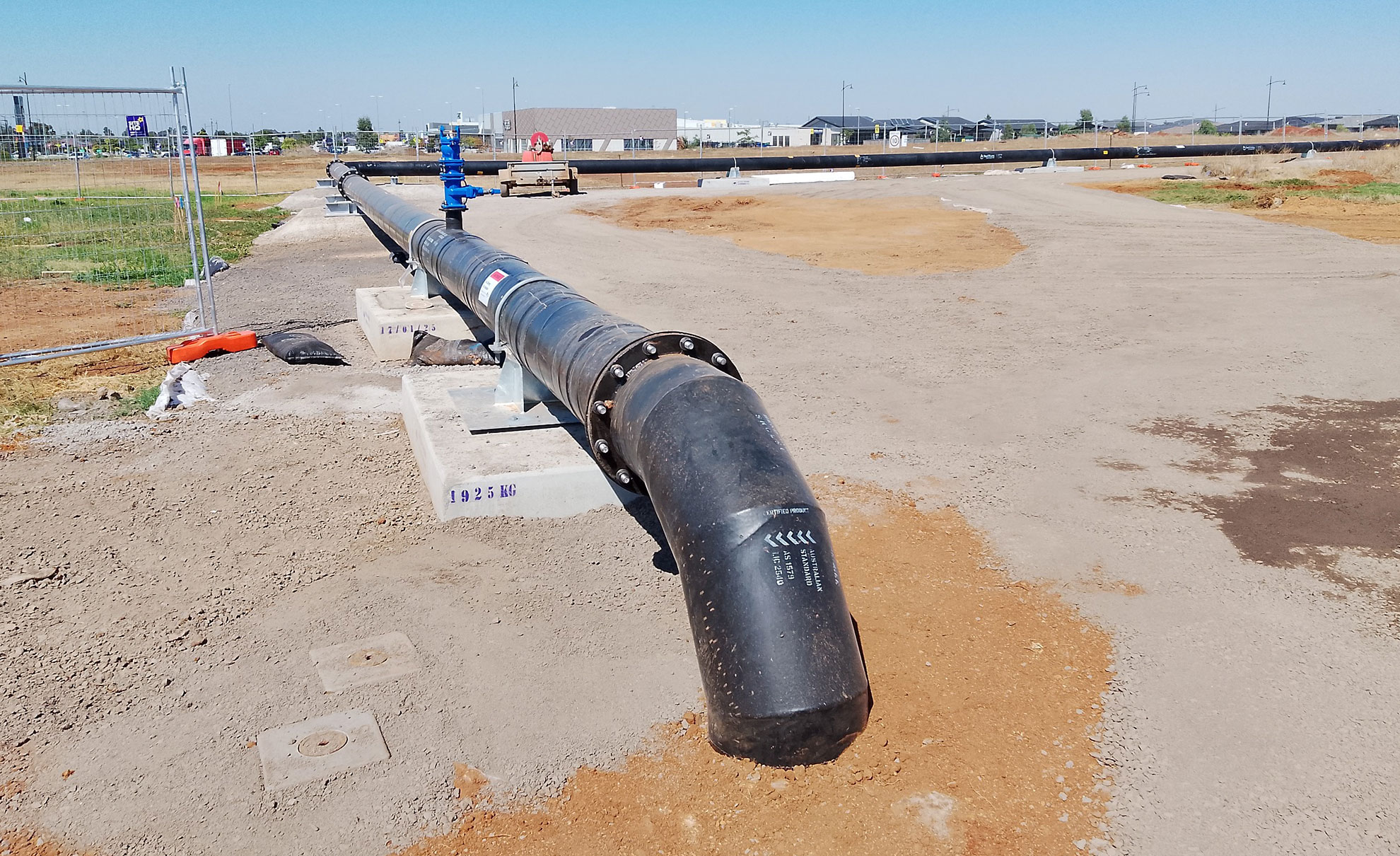 A long black pipe, approximately 45cm in diameter, resting on concrete stands.