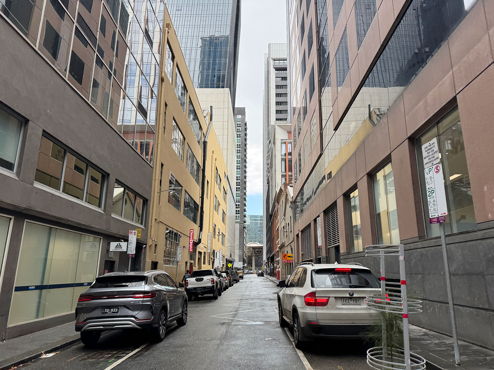 A view of a side street in the city with cars lining the sides of the road