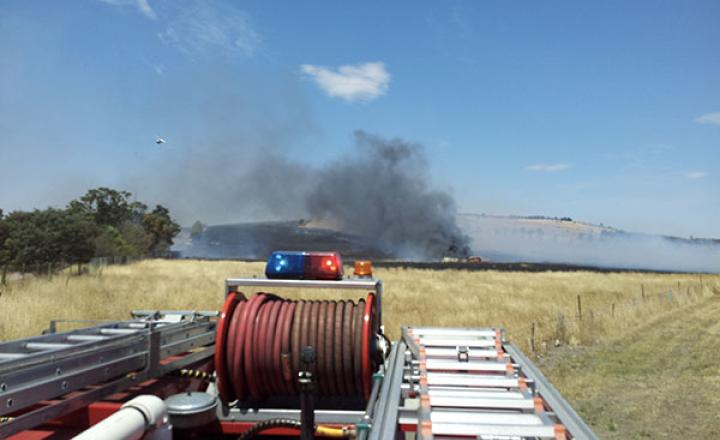 A photograph taken on the roof of a firetruck showing the smoke caused by a grass fire