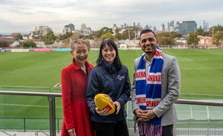 Three officials pose with a football.