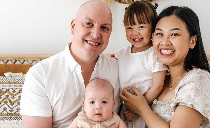 A family photograph, parents and children cuddling and smiling.