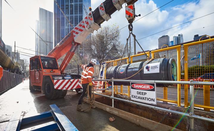 A small boring machine is loaded from a truck in to the ground