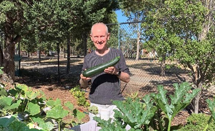 Stephen Holt showing his abundant zucchini harvest at the Food for Thought project’s community garden.