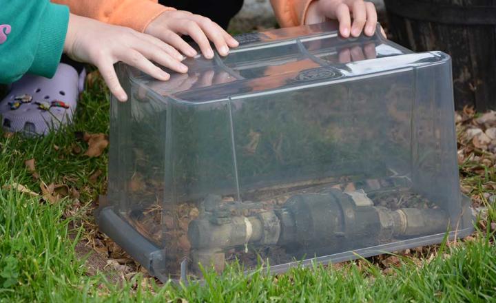 A clear plastic container is placed over the water meter to help prevent it from freezing during cold weather.