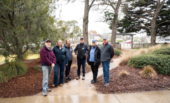 A group of 6 people standing in a public park