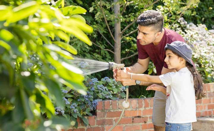 A person and child watering plants