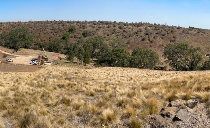 A landscape of hill side with cars and construction equipment in the background