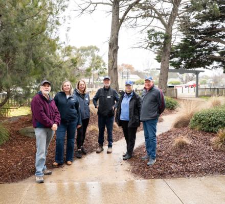 A group of 6 people standing in a public park