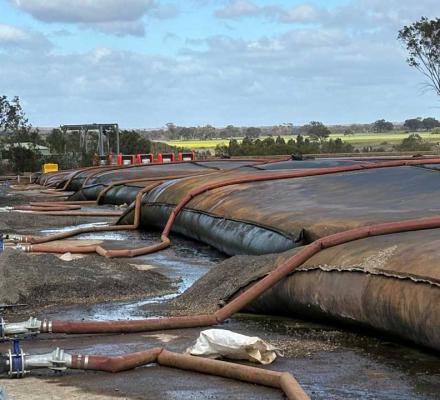 Very large, dirty bags filled with sludge that is being treated.