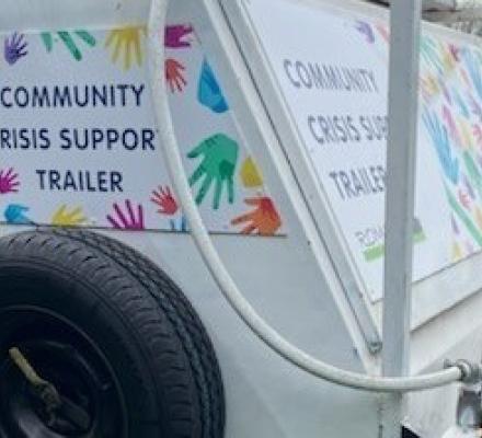 Romsey Neighborhood House Community Crisis Support Trailer on green grass.