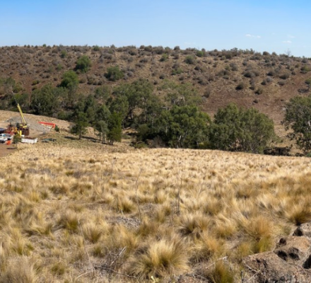 A landscape of hill side with cars and construction equipment in the background