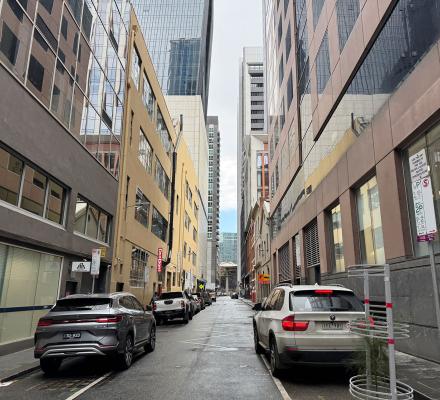 A view of a side street in the city with cars lining the sides of the road